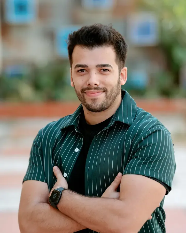 Luís Ribeiro, arms crossed, smiling, in a green pinstripe shirt outdoors